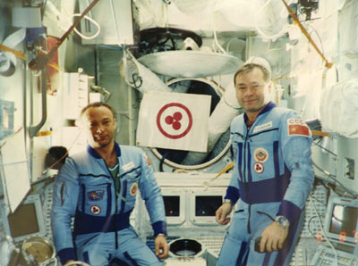 Космонавты А.Н. Баландин и Г.М. Стрекалов со Знаменем Мира на борту орбитального пилотируемого комплекса «Мир». Август 1990 г.